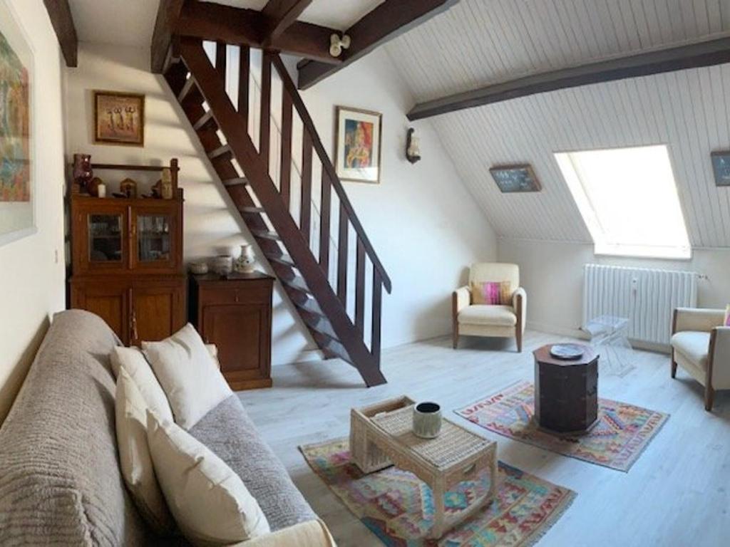 un salon avec un canapé et un escalier dans l'établissement Appart T2 Mezzanine au cœur de La Baule - FR-1-392-243, à La Baule