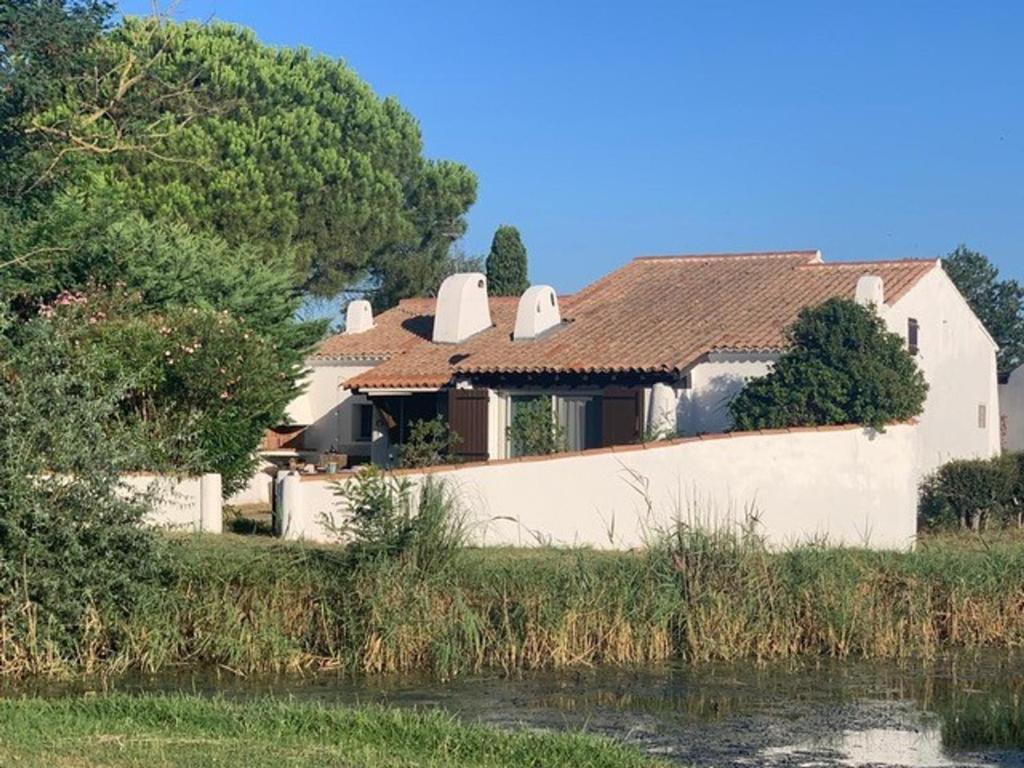 une maison au bord d'une rivière dans l'établissement Maison 8 pers, jardin privatif, climatisation, animaux admis - FR-1-475-185, à Saintes-Maries-de-la-Mer