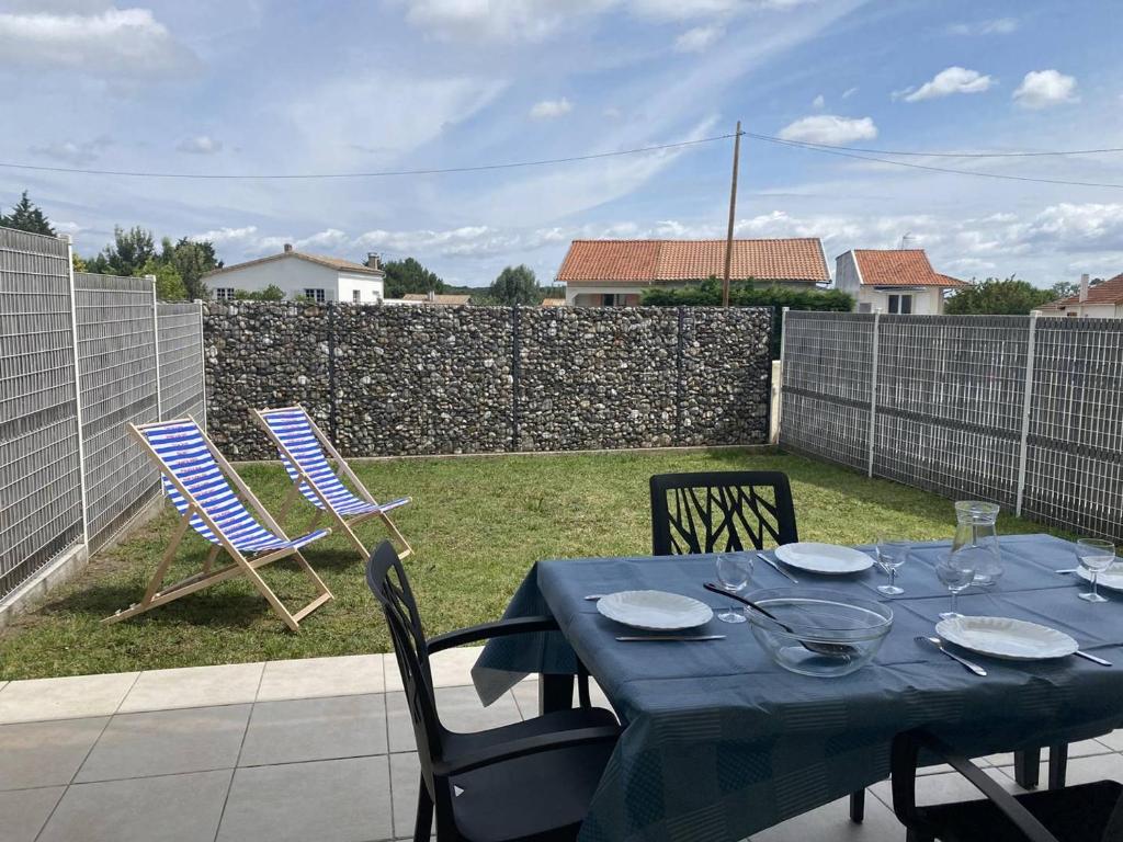 une table et des chaises bleues sur une terrasse dans l'établissement T2 2* avec Terrasse & Jardinet - 400m Plage - FR-1-738-45, à Saint-Palais-sur-Mer