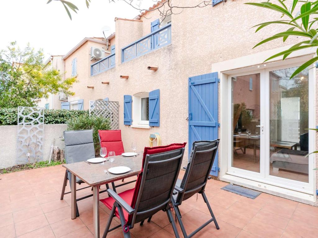 un patio avec une table et des chaises et un bâtiment dans l'établissement Villa 3 pièces à Narbonne-Plage, animaux acceptés - FR-1-409-276, à Narbonne