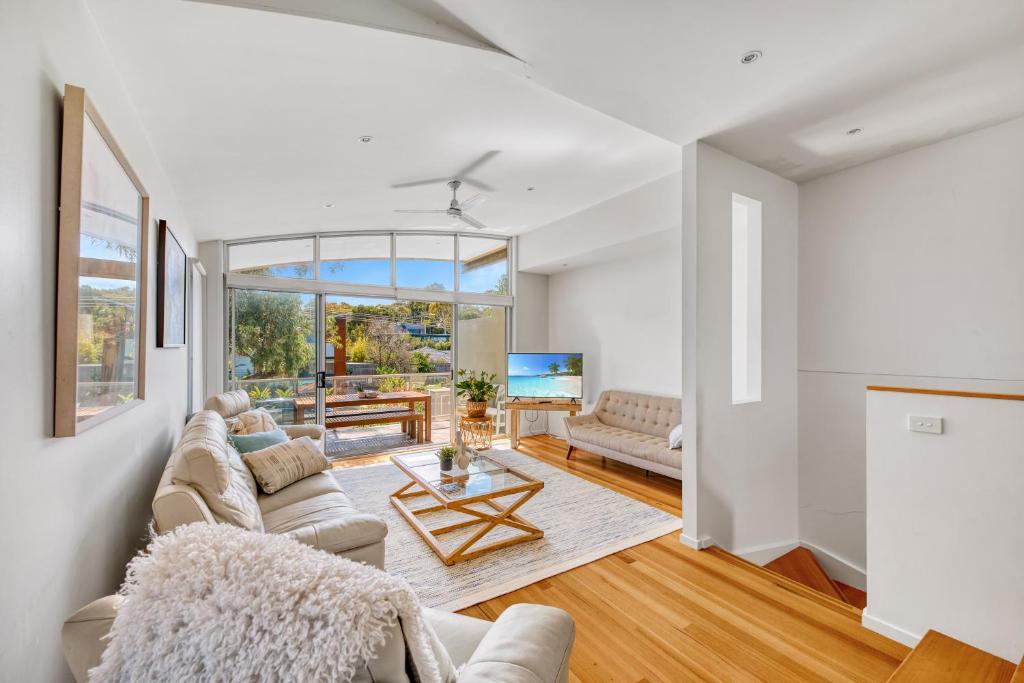 a living room with two couches and a table at Jan Juc Beach Home in Torquay