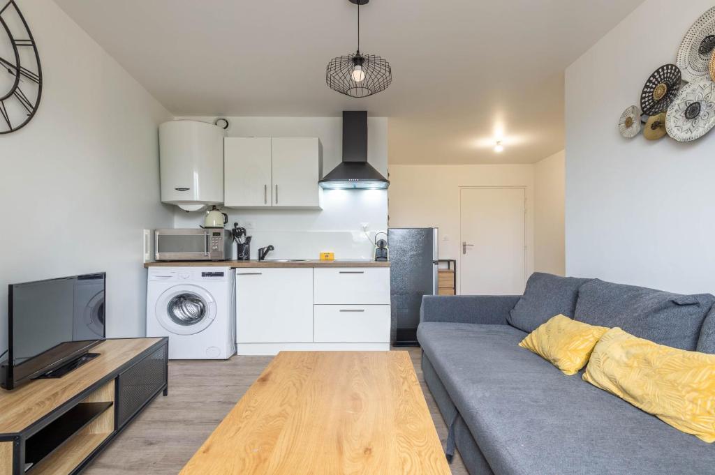 un salon avec un canapé bleu et une cuisine dans l'établissement M5 Marquer Beau t2 centre ville, à Annemasse