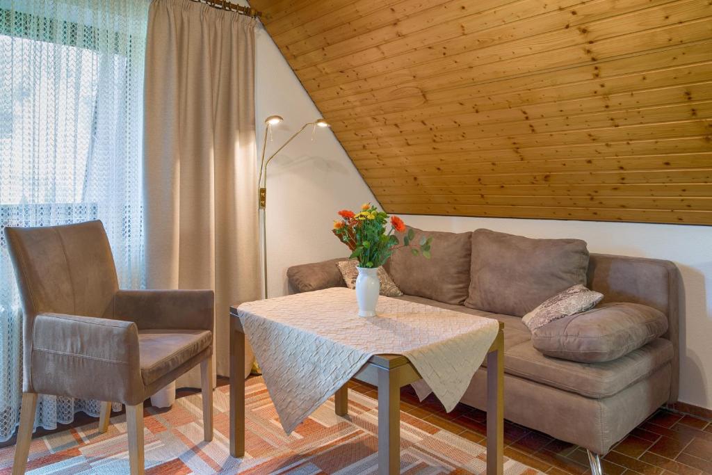 a living room with a couch and a table and chairs at Drei Tannen - Wohnung 12 - Apartmenthaus, Titisee, nahe Badeparadies in Titisee