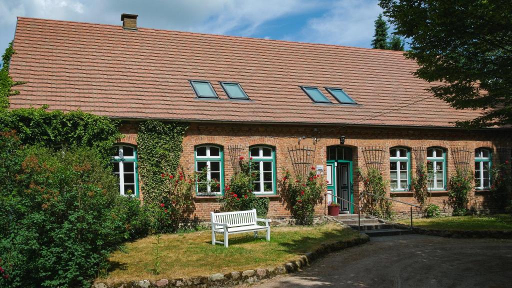 a brick house with a bench in front of it at Ferienwohnung im Pfarrhaus Kölzow in Kölzow