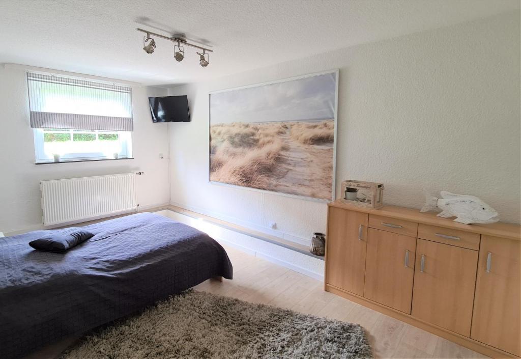 a bedroom with a bed and a large painting on the wall at Bootshaus Nr 6 in Grömitz