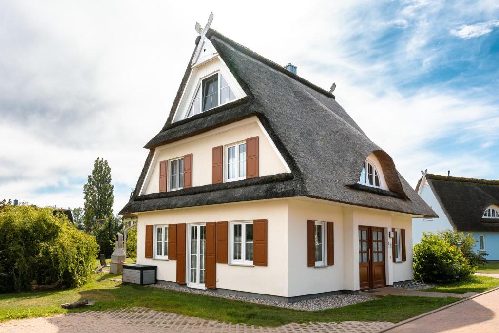 a small house with a gambrel roof at C 4 Reethaus ELSA mit Außenwhirlpool und Sauna in Gramkow