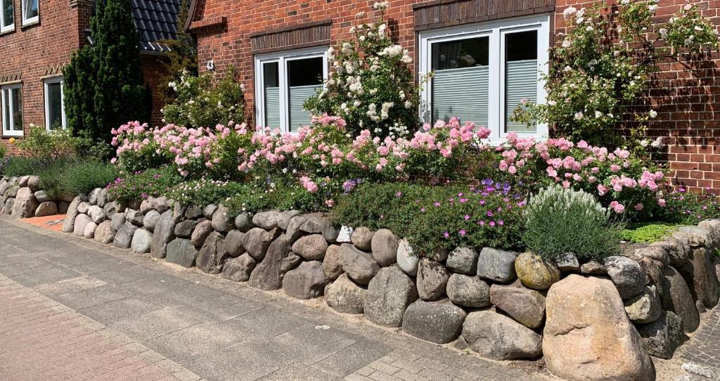 a garden with rocks and flowers in front of a building at Ferienwohnung in der Schleife in Rendsburg