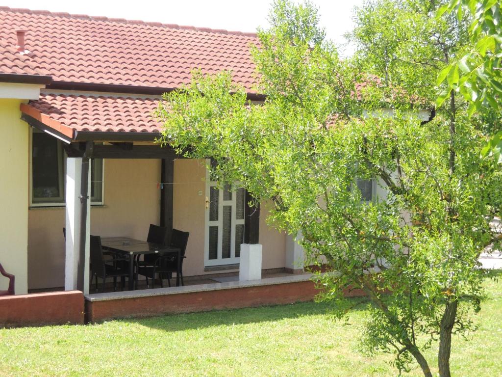 dom z patio ze stołem i krzesłami w obiekcie Residence Lorena Bungalow Lavanda 1 w Poreču