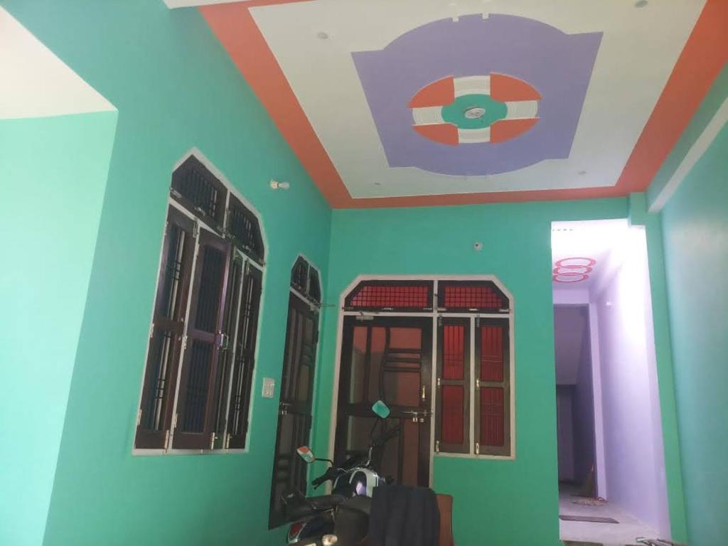 a room with blue and green walls and windows at Swastik HomeStay in Ayodhya