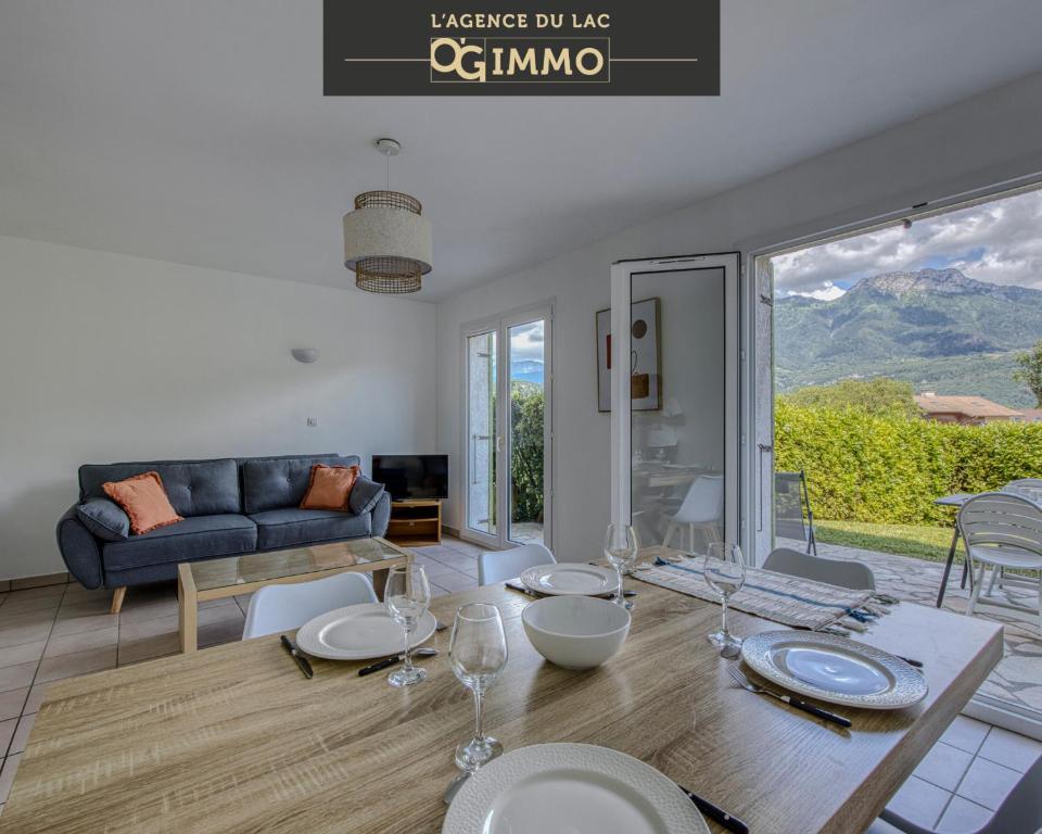 un salon avec une table et un canapé dans l'établissement Les jardins de Duingt, à Duingt