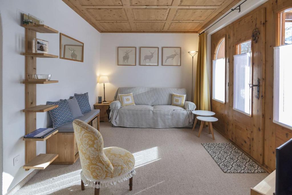a living room with a couch and a chair at Chesa Aurora - La Punt in La Punt-Chamues-ch