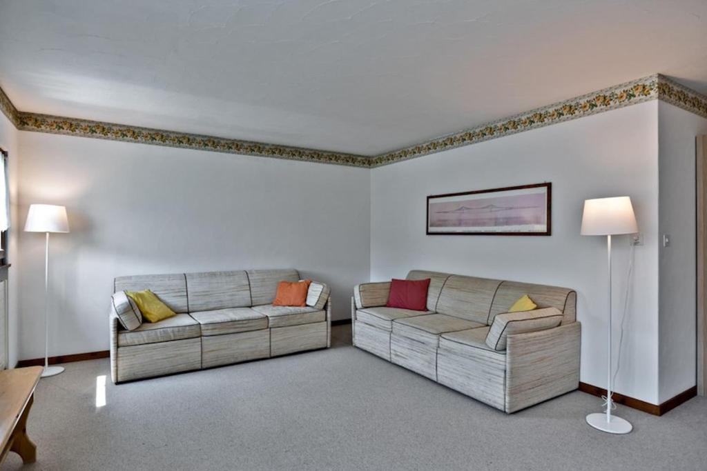 a living room with two couches and two lamps at Chesa Chavriol 2 - Celerina in Celerina