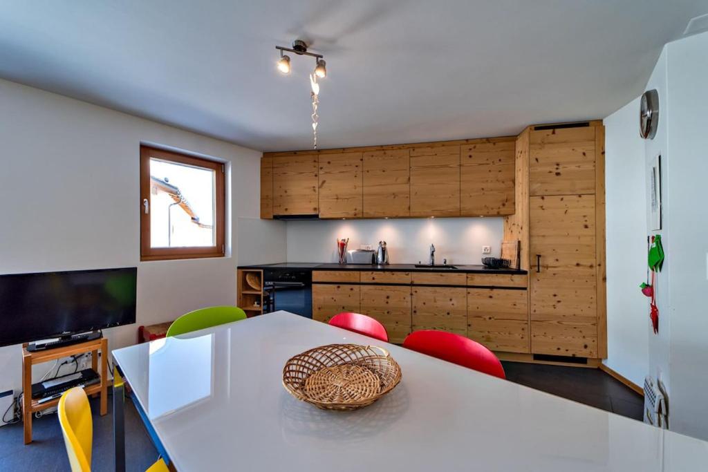 a kitchen with a white table and some chairs at Engadina Chesa Gluna - Madulain in Madulain
