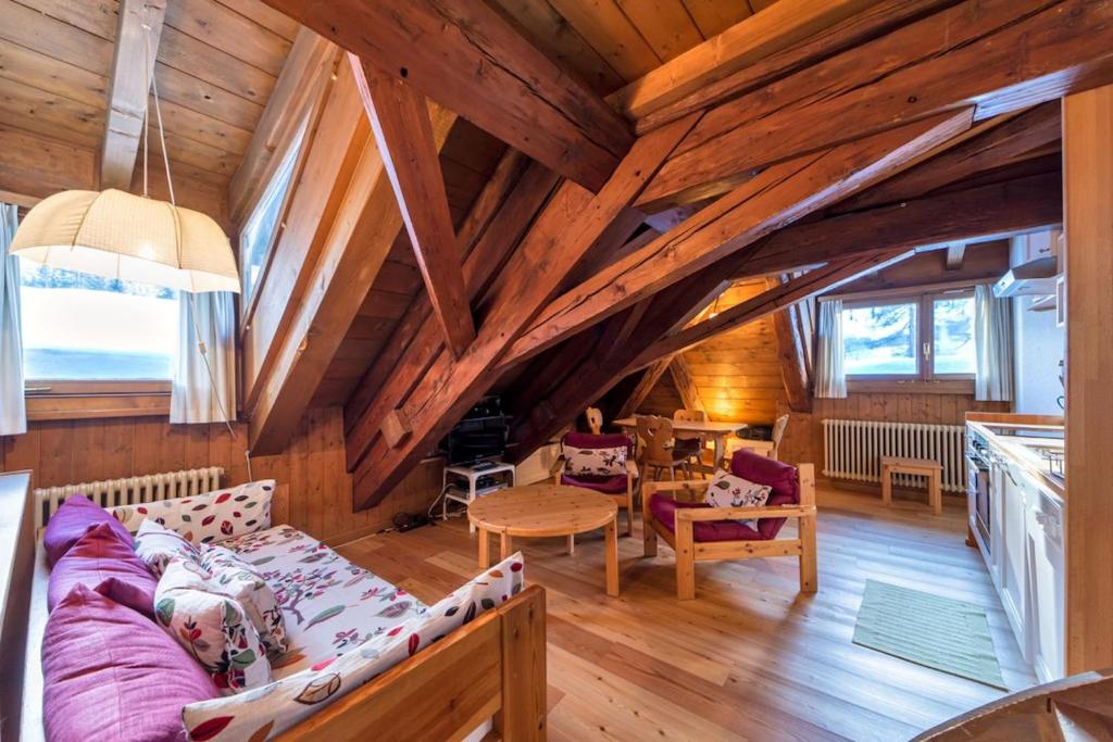 a living room in a wooden house with wooden ceilings at Chesa La Cuntainta - Sils Maria in Sils Maria