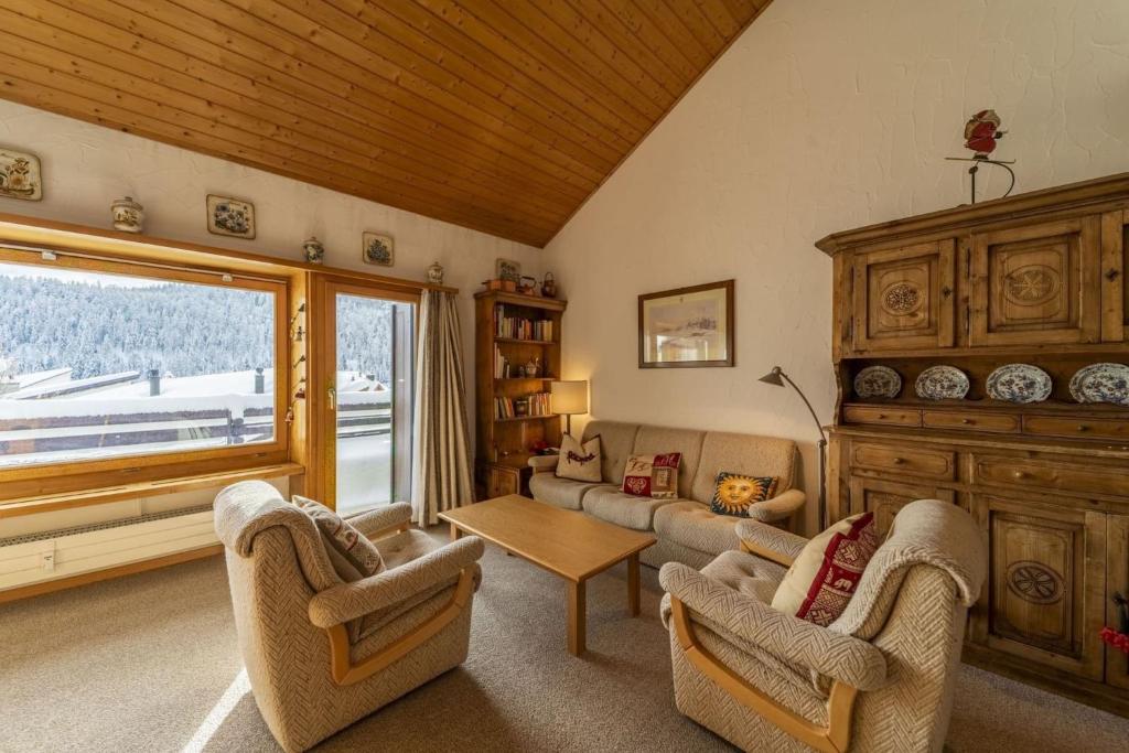 a living room with a couch and chairs and a window at Chesa Panorama - Celerina in Celerina