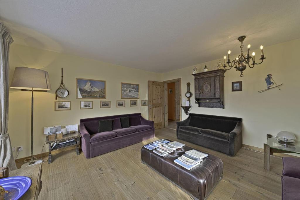 a living room with two couches and a chandelier at Chesa Charots - Celerina in Celerina