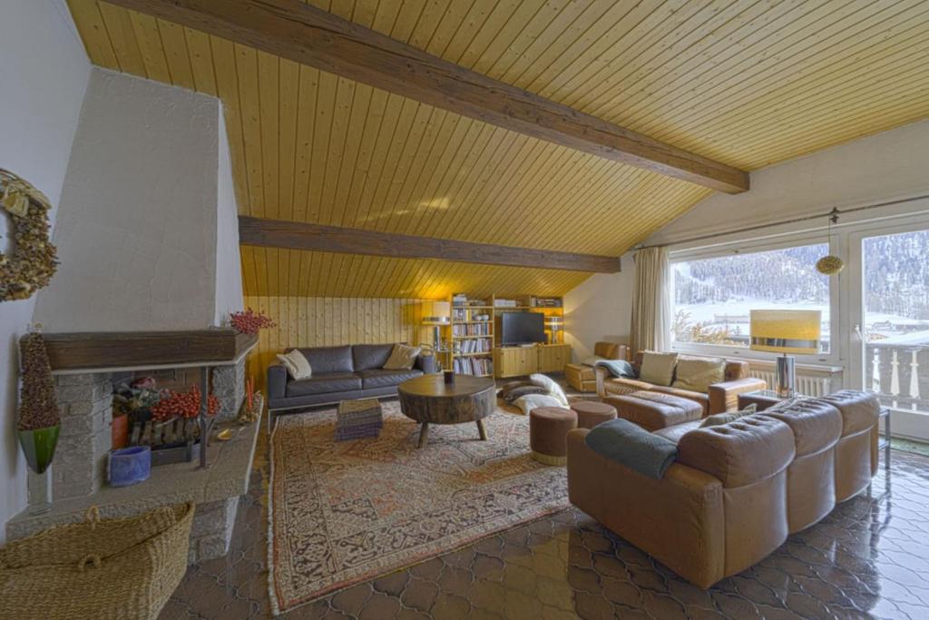 a living room with couches and a fireplace at Chesa Clus - Zuoz in Zuoz