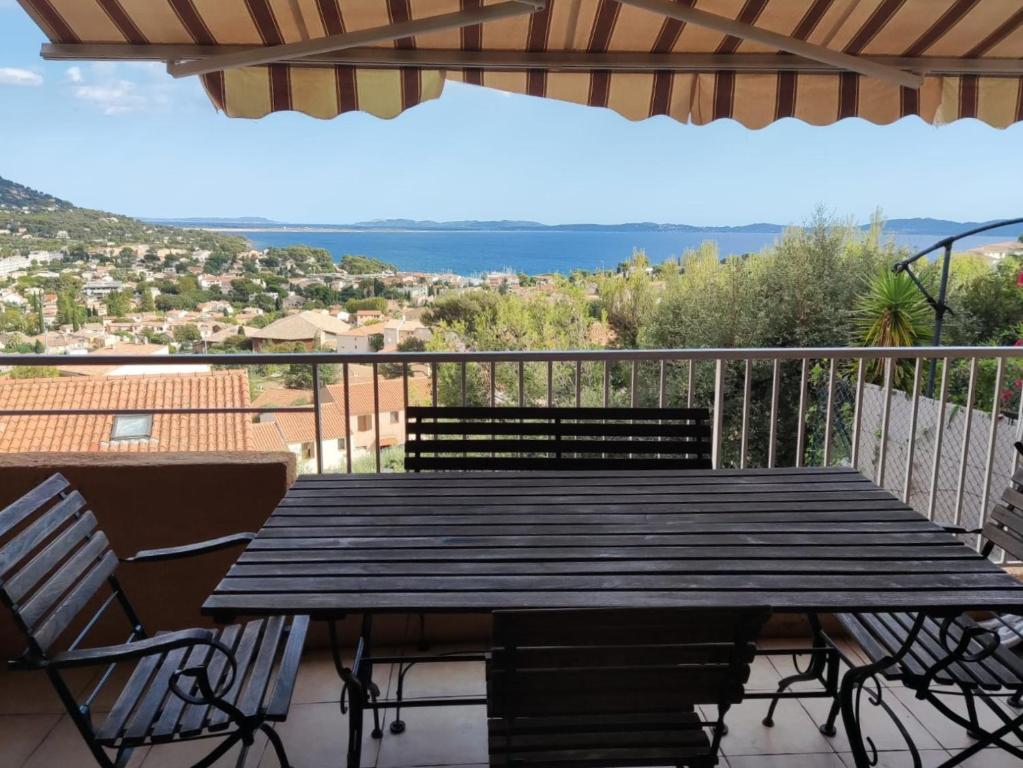 stół i krzesła na balkonie z widokiem w obiekcie 2-room apartment with a magnificent view of the sea, in carqueiranne in the var, 12km from the isles de porquerolles boarding port – 2/4 people w mieście Carqueiranne