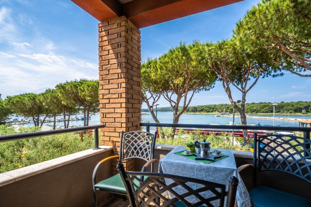 a table and chairs on a balcony with a view of the water at Apartments Oliveto - Calming Sea View in Medulin