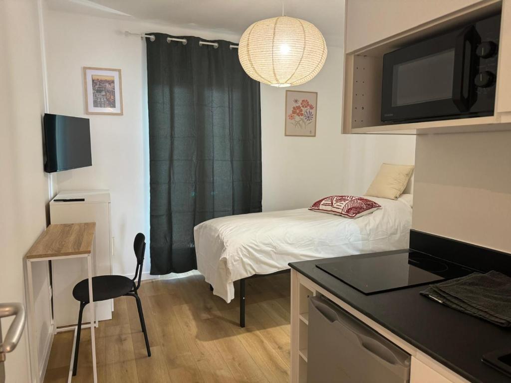 Cette petite chambre comprend un lit et une cuisine. dans l'établissement M97 Marquer joli studio Faucigny, à Annemasse