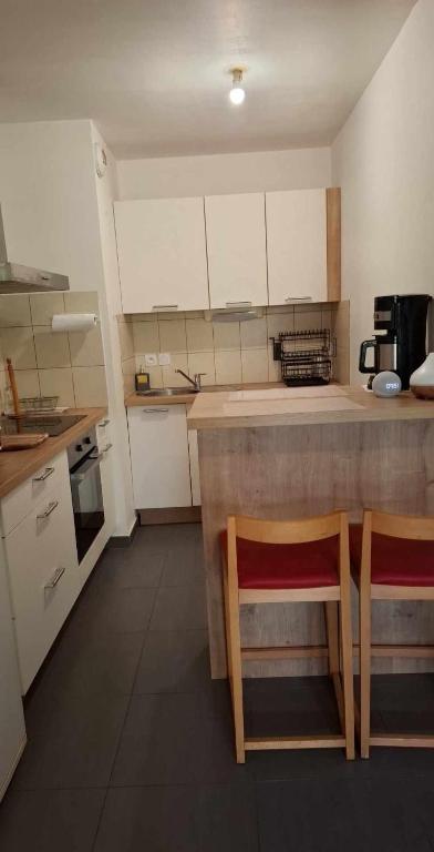 - une petite cuisine avec 2 chaises et un comptoir dans l'établissement Cosi, à Gex