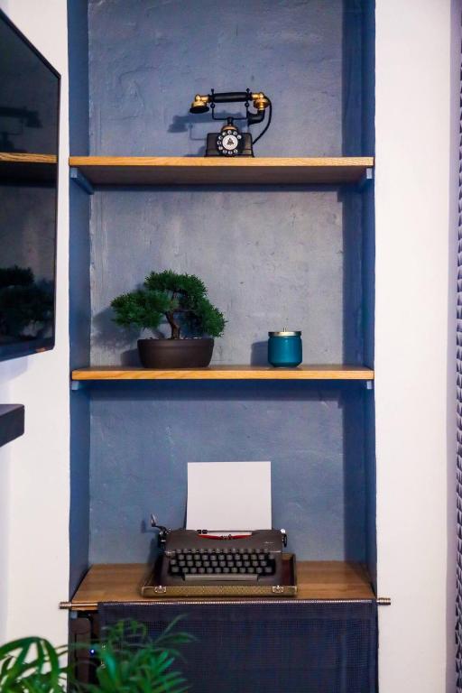 une étagère avec une machine à écrire et une horloge sur elle dans l'établissement M81 Marquer joli t2 proche de la gare, à Annemasse