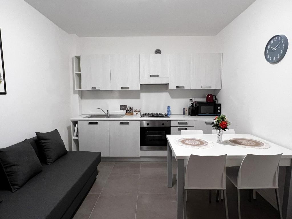 a kitchen and living room with a couch and a table at Scala Santa Apartment in Trieste