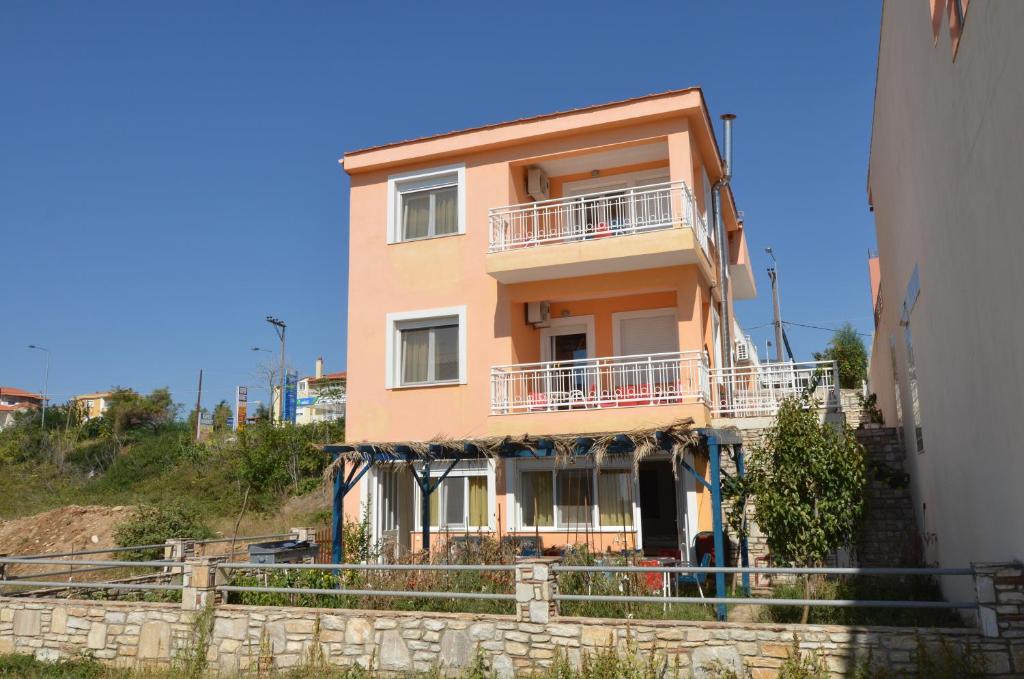 a house on a hill next to a wall at Avra Apartments in Limenaria