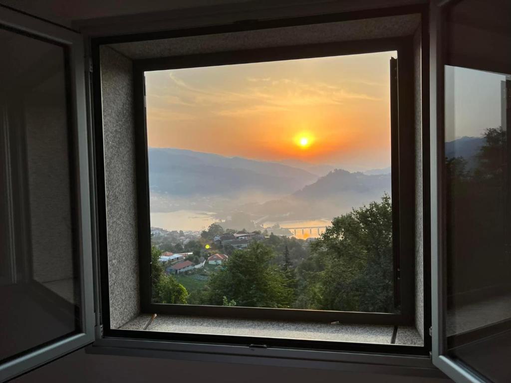 a view of a sunset from a window at Assossego House - Gerês in Geres