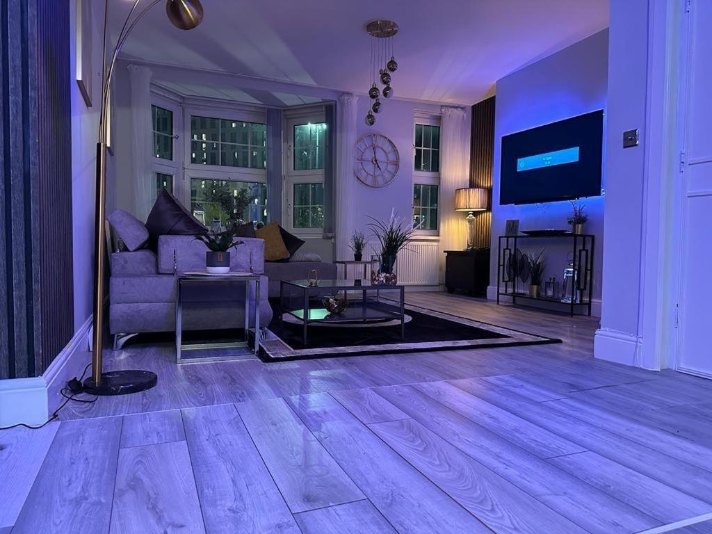 a living room with a couch and a table at Lush Jacuzzi Apartment 2 Bedrooms with Balcony & Parking in Birmingham