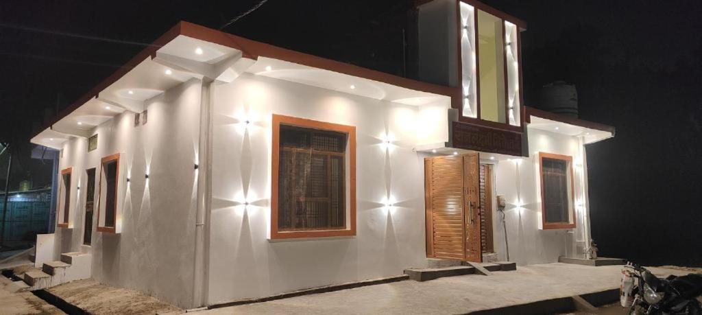 a white building with windows and lights on it at Rajlaxmi Niketan in Ayodhya