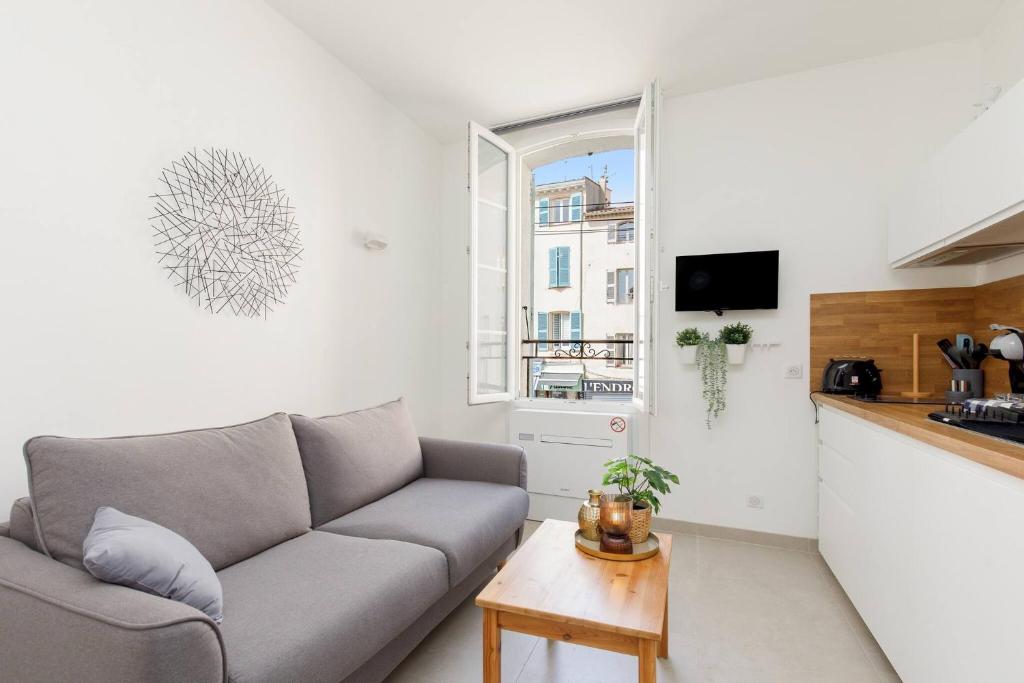 un salon avec un canapé et une cuisine dans l'établissement Petit bijou de la vieille ville, à Antibes