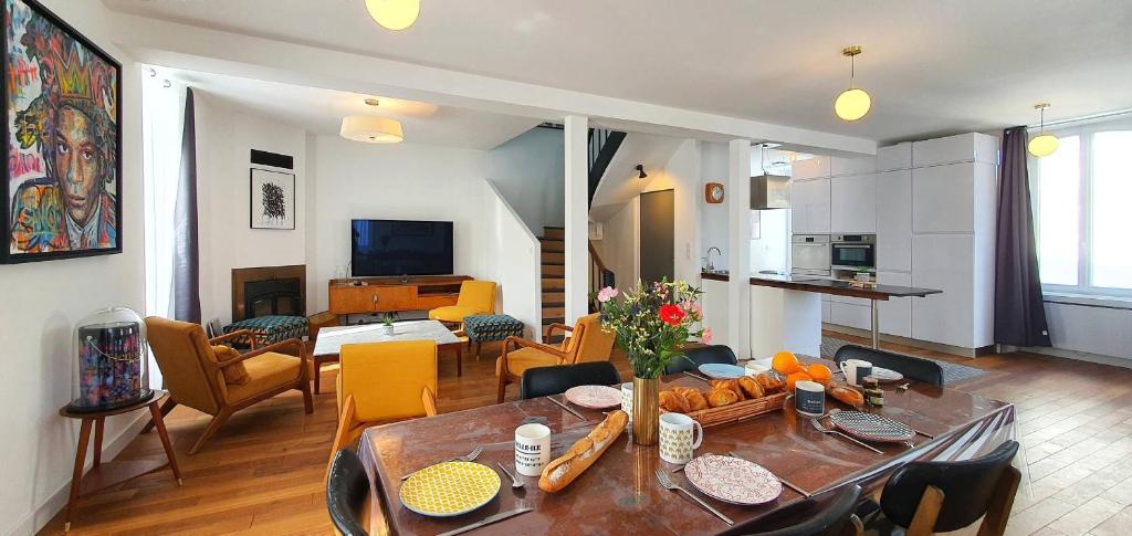ein Wohnzimmer mit einem Tisch und ein Esszimmer in der Unterkunft Maison de Ville Ty Art in Quiberon