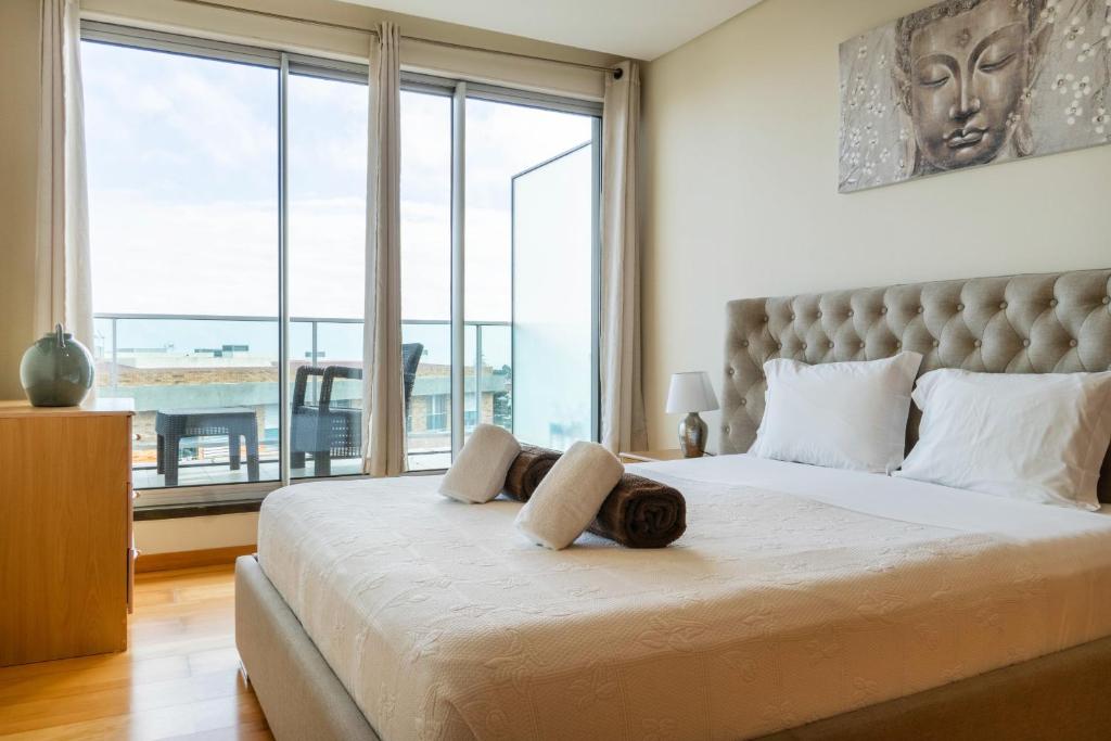 a bedroom with a large bed with a large window at Rooftop Terrace Apartment PDL in Ponta Delgada