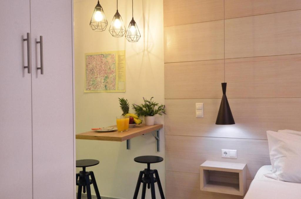 sypialnia z łóżkiem i 2 stołkami barowymi w obiekcie Petralona, a sweet and cozy apartment w Atenach