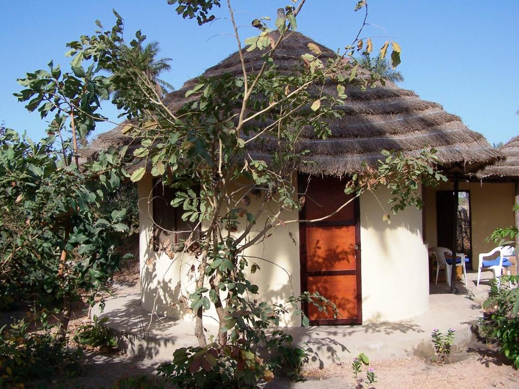 a small white house with a thatched roof at Bendula in Tujering