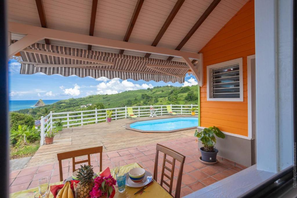 a patio with a table and chairs and a swimming pool at Bungalow avec piscine au cœur de la Campagne Oge in Sainte-Marie