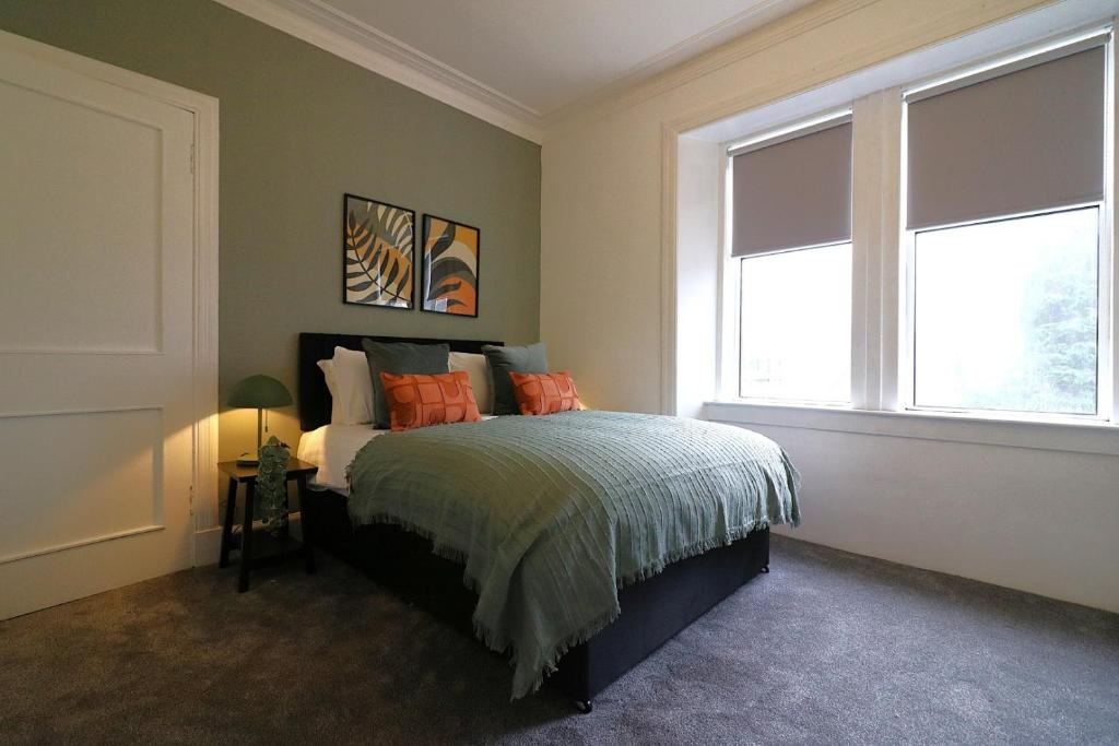 a bedroom with a bed and two windows at Signature - St James House in Abbotsinch