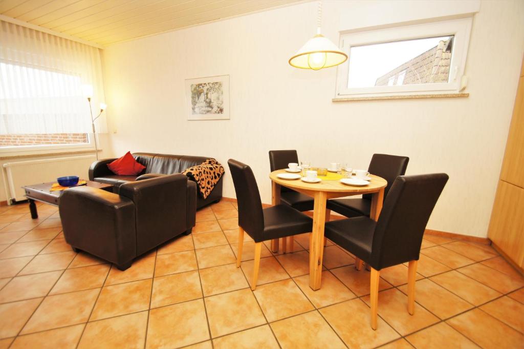 ein Wohnzimmer mit Tisch, Stühlen und Sofa in der Unterkunft "Haus Stefanie" Bungalow -1- in Dahme