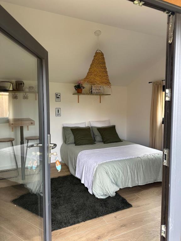 une chambre avec un lit et une table en verre dans l'établissement La Cabane du Mascaret, à Vayres