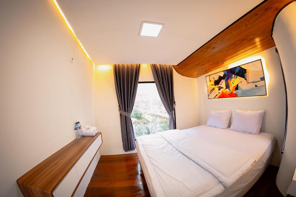 a bedroom with a large bed and a window at Kayana cabin dieng in Wonosobo