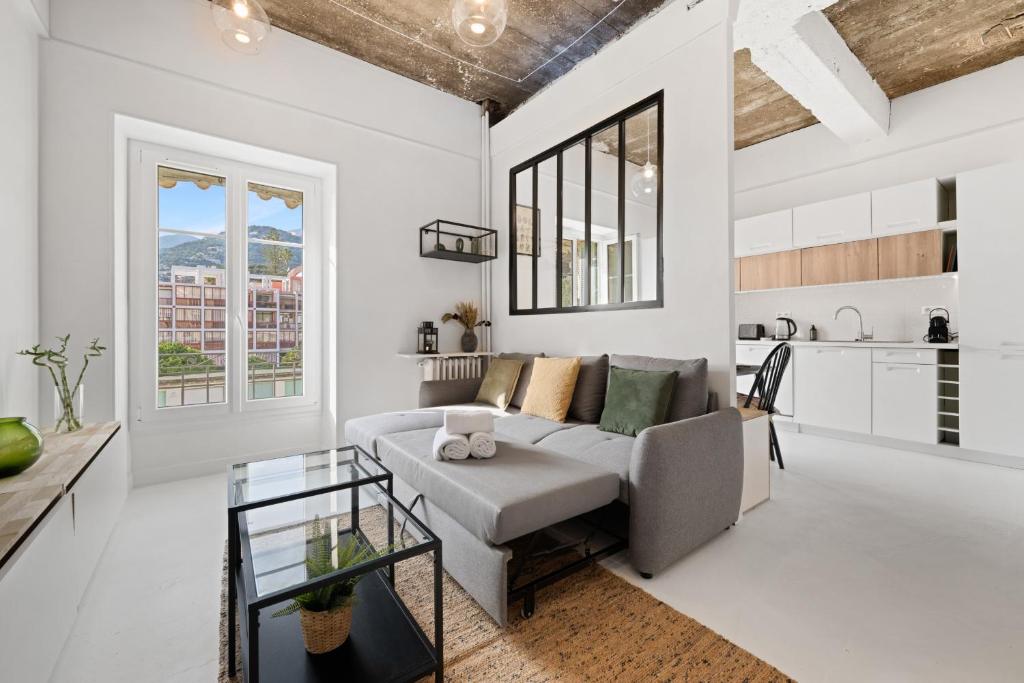 un salon avec un canapé et une table dans l'établissement L Écrin du Palace, cosy 2 pièces, à Menton