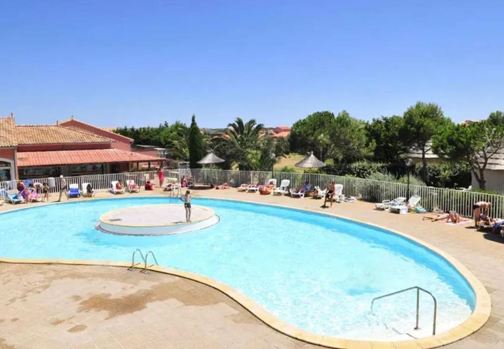 - une piscine dans un complexe avec une personne debout dans l'établissement Maison confortable à Le Barcarès 33 m² avec piscine partagée, au Barcarès