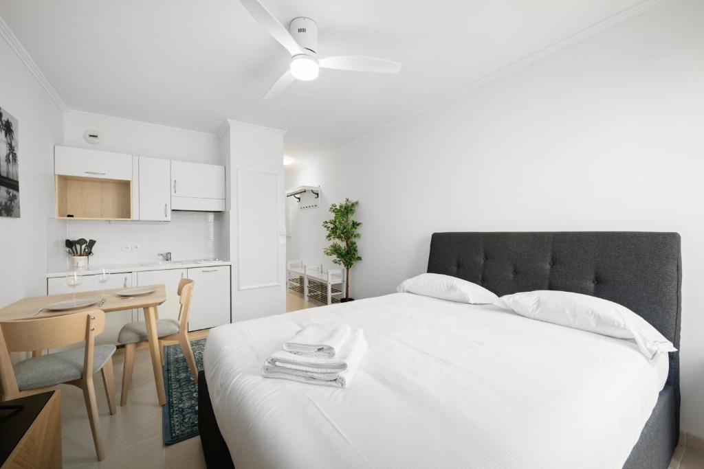 Cet appartement comprend une chambre avec un lit blanc et une petite cuisine. dans l'établissement Studio pour deux très jolie au centre ville, à Menton