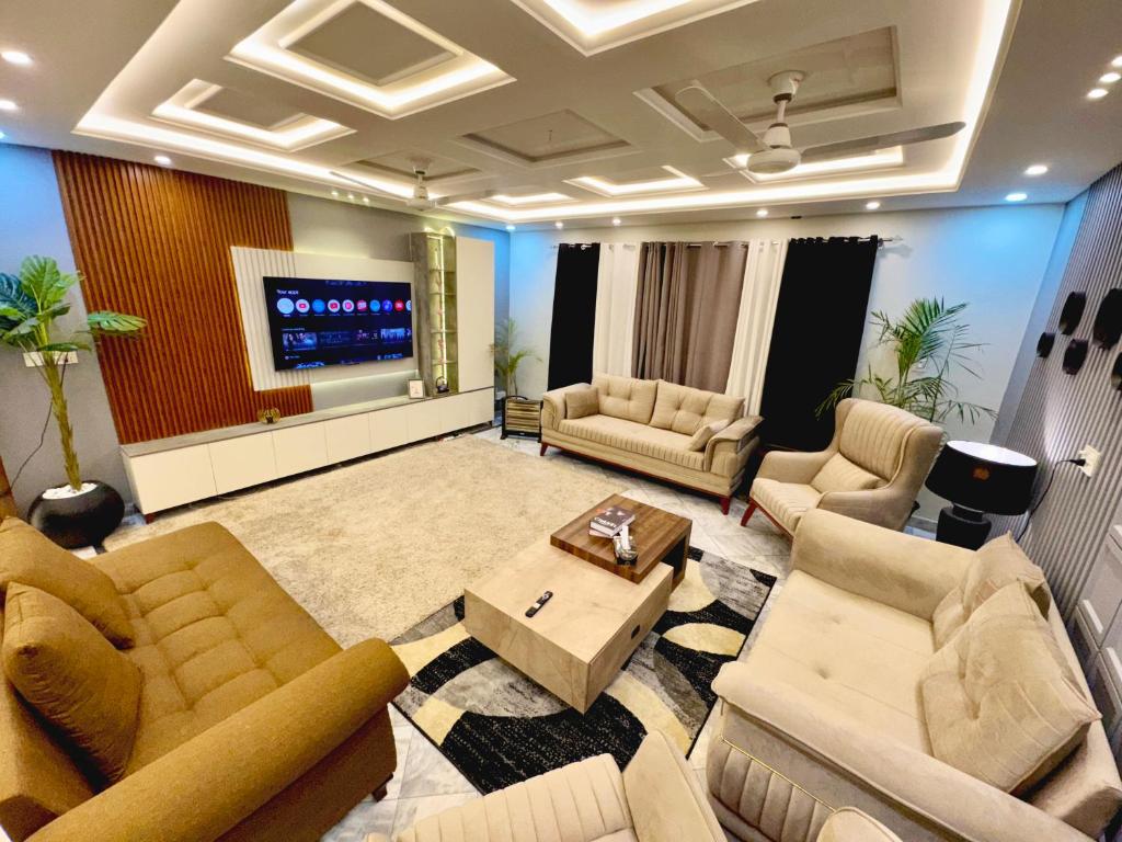 a living room with couches and a flat screen tv at Luxury kanal portion in Islamabad in Islamabad
