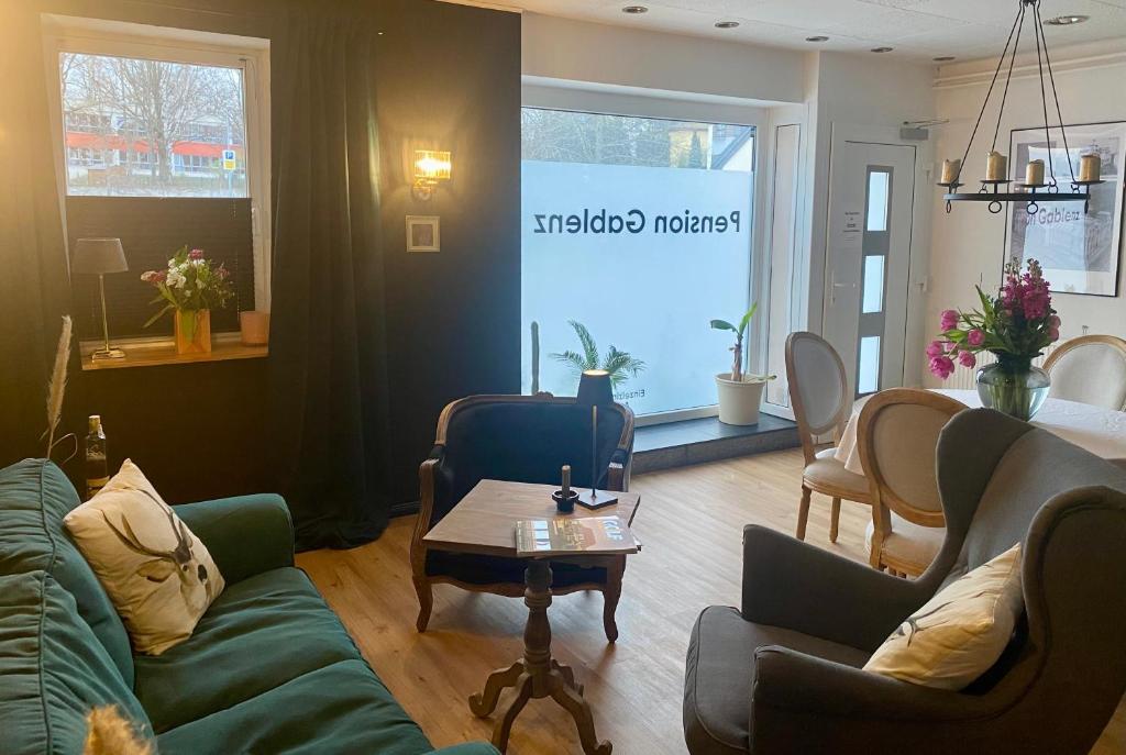 a living room with a couch and chairs and a table at Pension Gablenz in Chemnitz