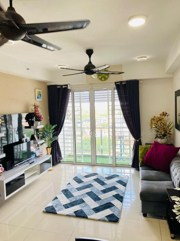 Una sala de estar con un sofá y un ventilador de techo. en EM Suite Home 2Bedroom, en Kota Bharu