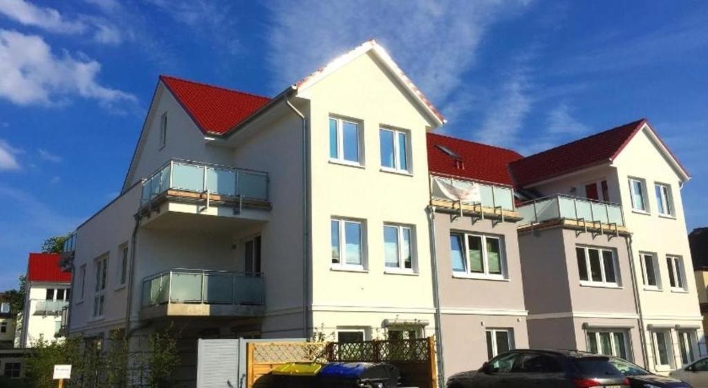 a large white house with red roofs at FeWo Grosse Nr 6 in Kellenhusen