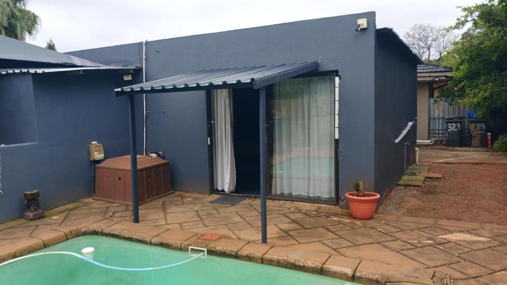 ein blaues Haus mit einem Swimmingpool davor in der Unterkunft 329 on 30th Avenue Villieria Jimmy in Pretoria