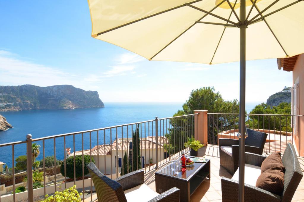 a balcony with an umbrella and a view of the ocean at Villa with incredible sea views and pool Up To 7 in Andratx
